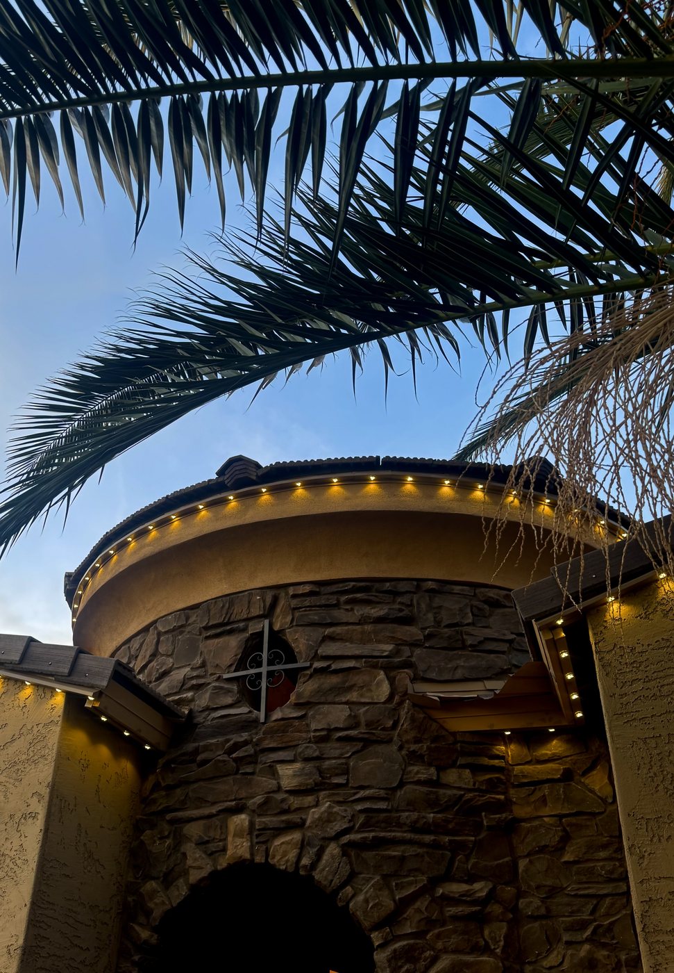 Modern stucco home at twilight with warm eave lighting
