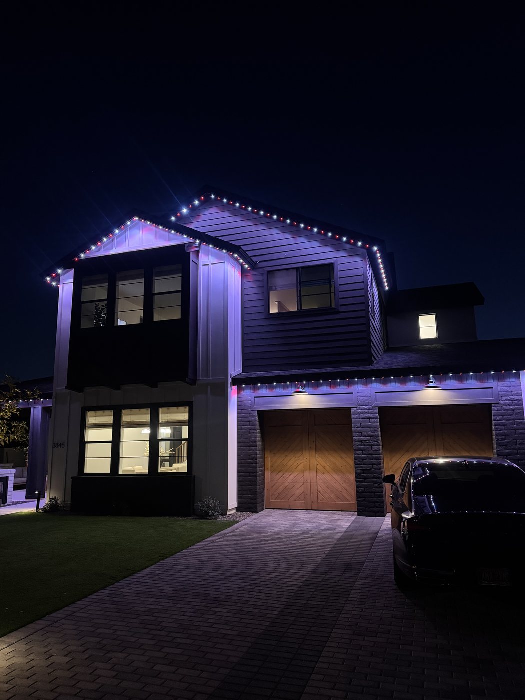 Two-story home with multicolor permanent LED holiday display